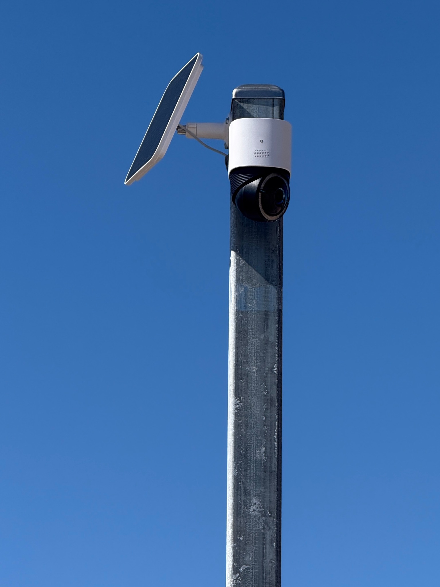 LotWatch solar and cellular camera mounted on a galvanized pole beneath a clear blue sky